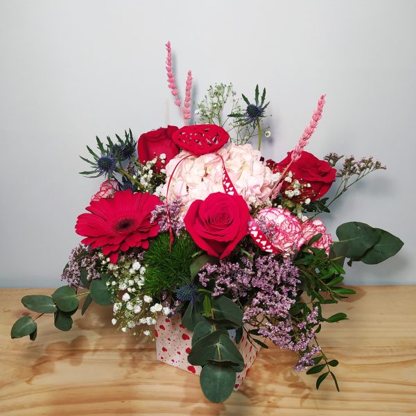 Arreglo floral romántico con rosas rojas y claveles